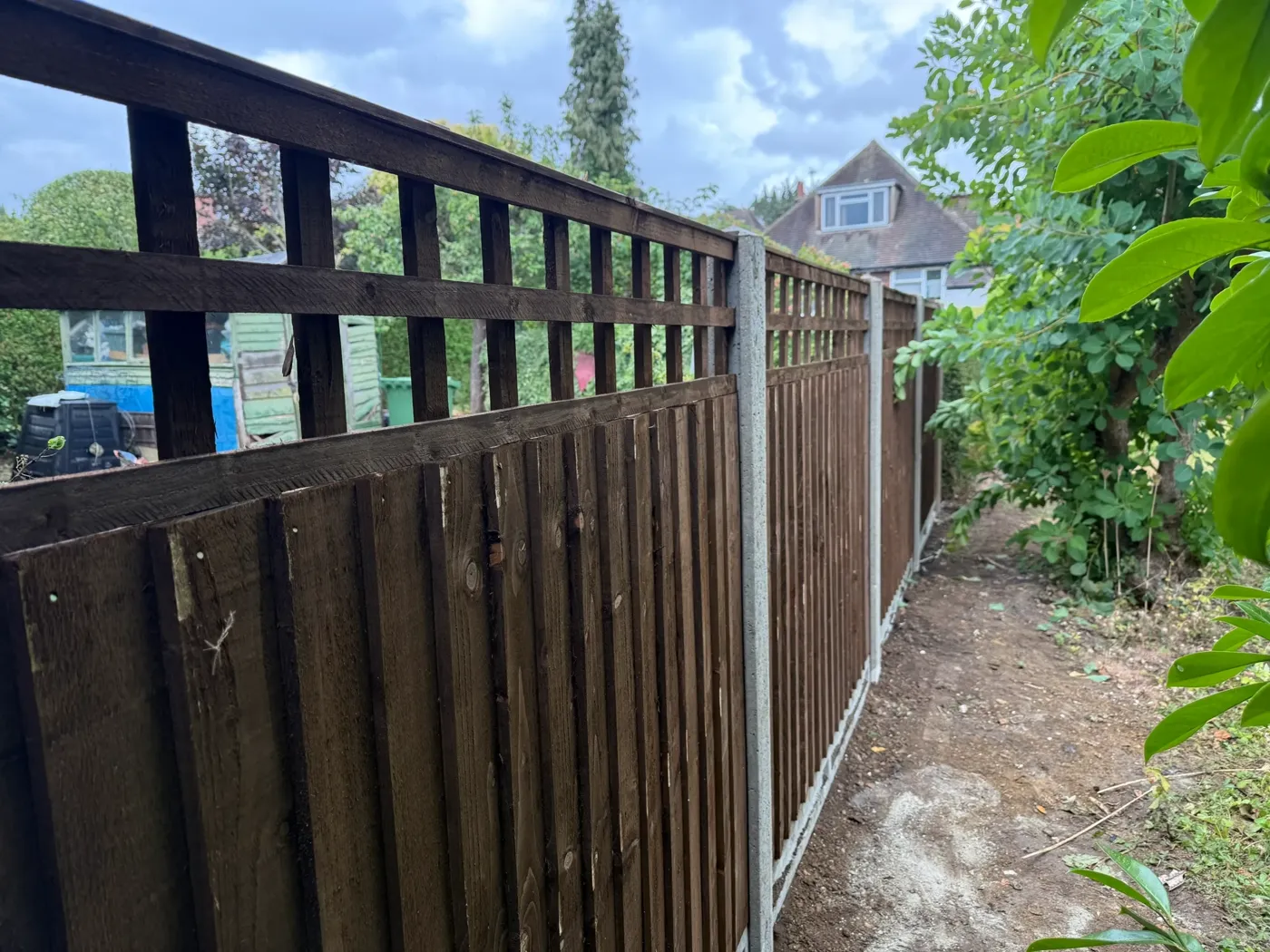 Feather edge fencing fitted on a sloping garden boundary