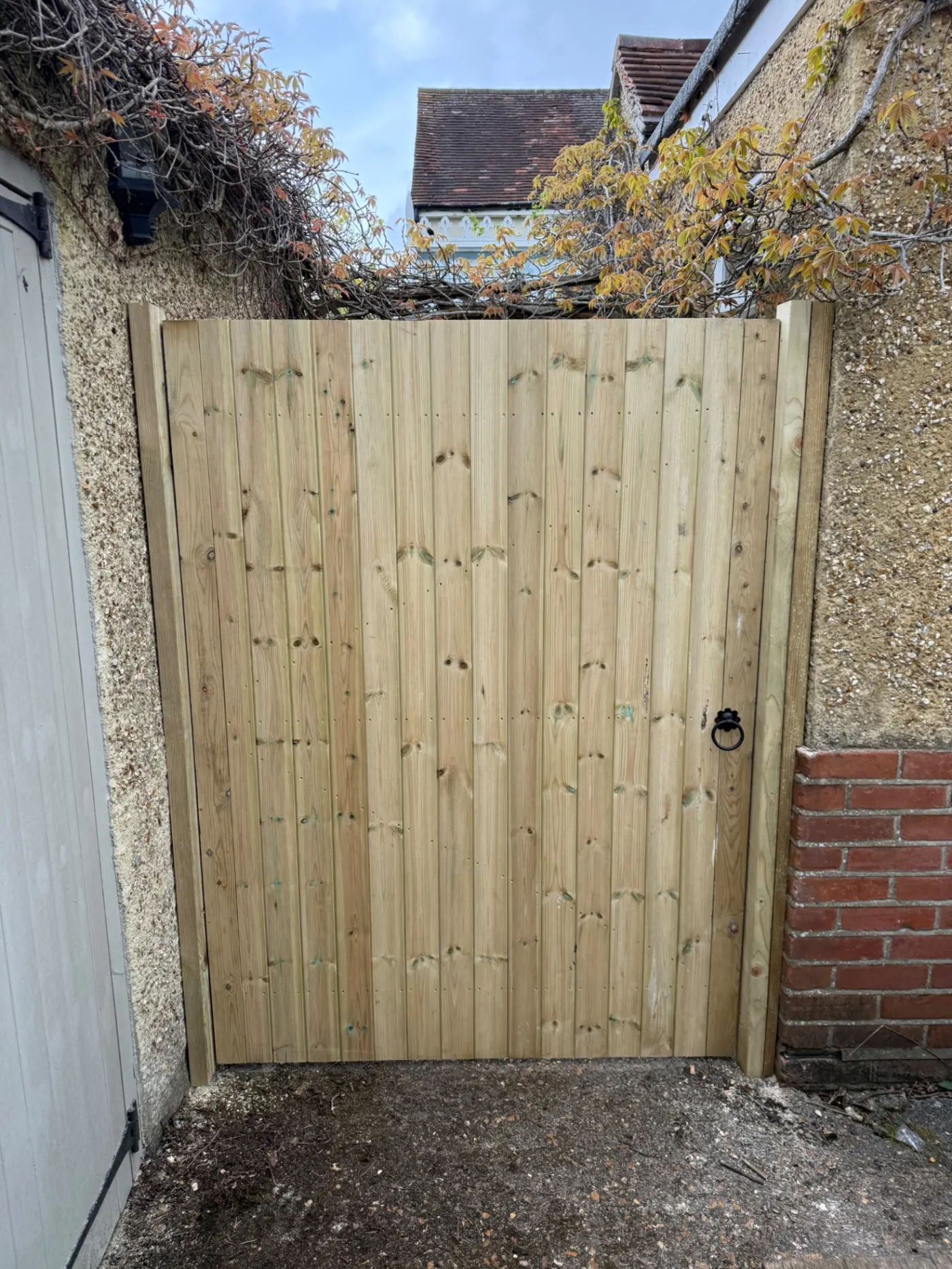 Tongue and groove timber side gate fitted beside a house
