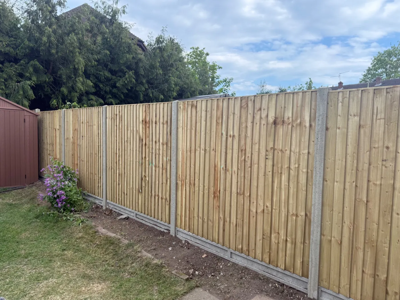 Long run of closeboard fence panels and gravel boards in a Guildford garden