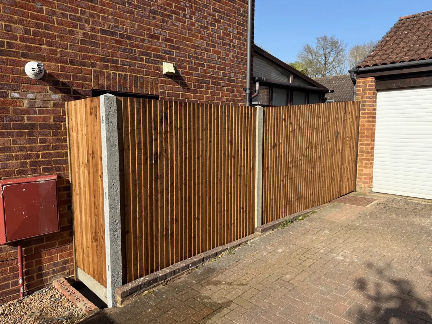 Closeboard fencing screening a driveway beside a garage