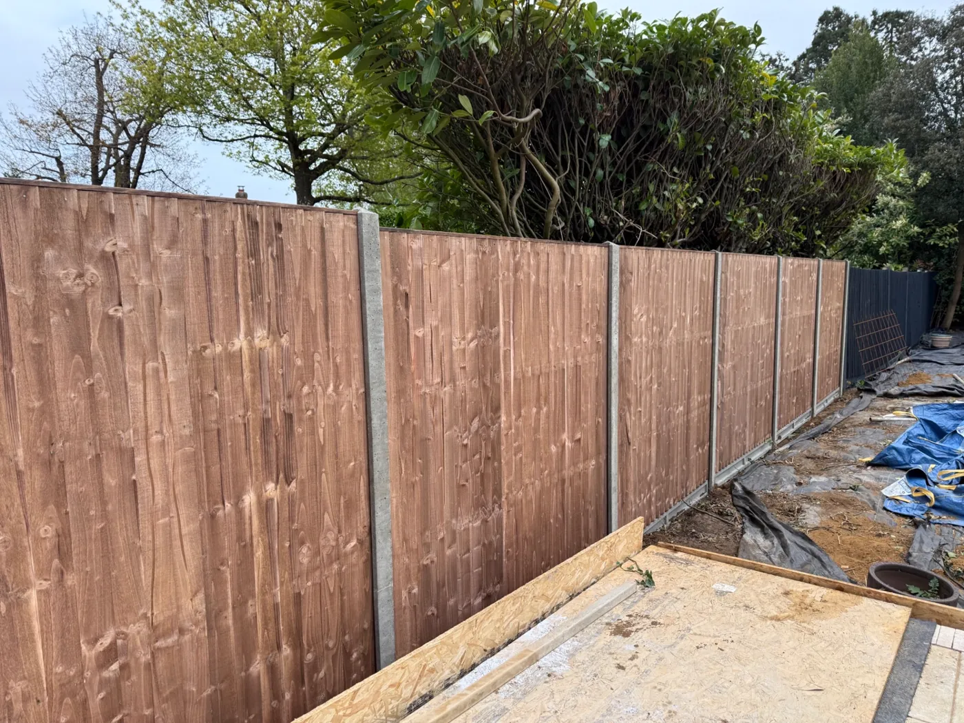 Closeboard fence line with concrete posts during a garden rebuild