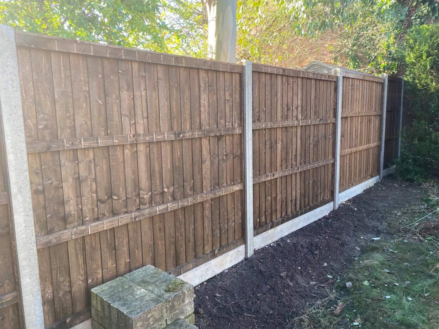 Brown closeboard fence panels fitted with concrete posts and gravel boards in a Guildford garden