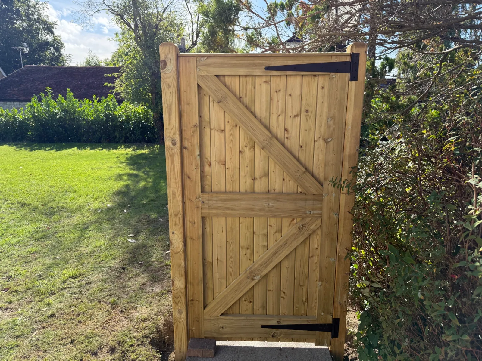 Braced timber garden gate hung on posts in a Guildford garden