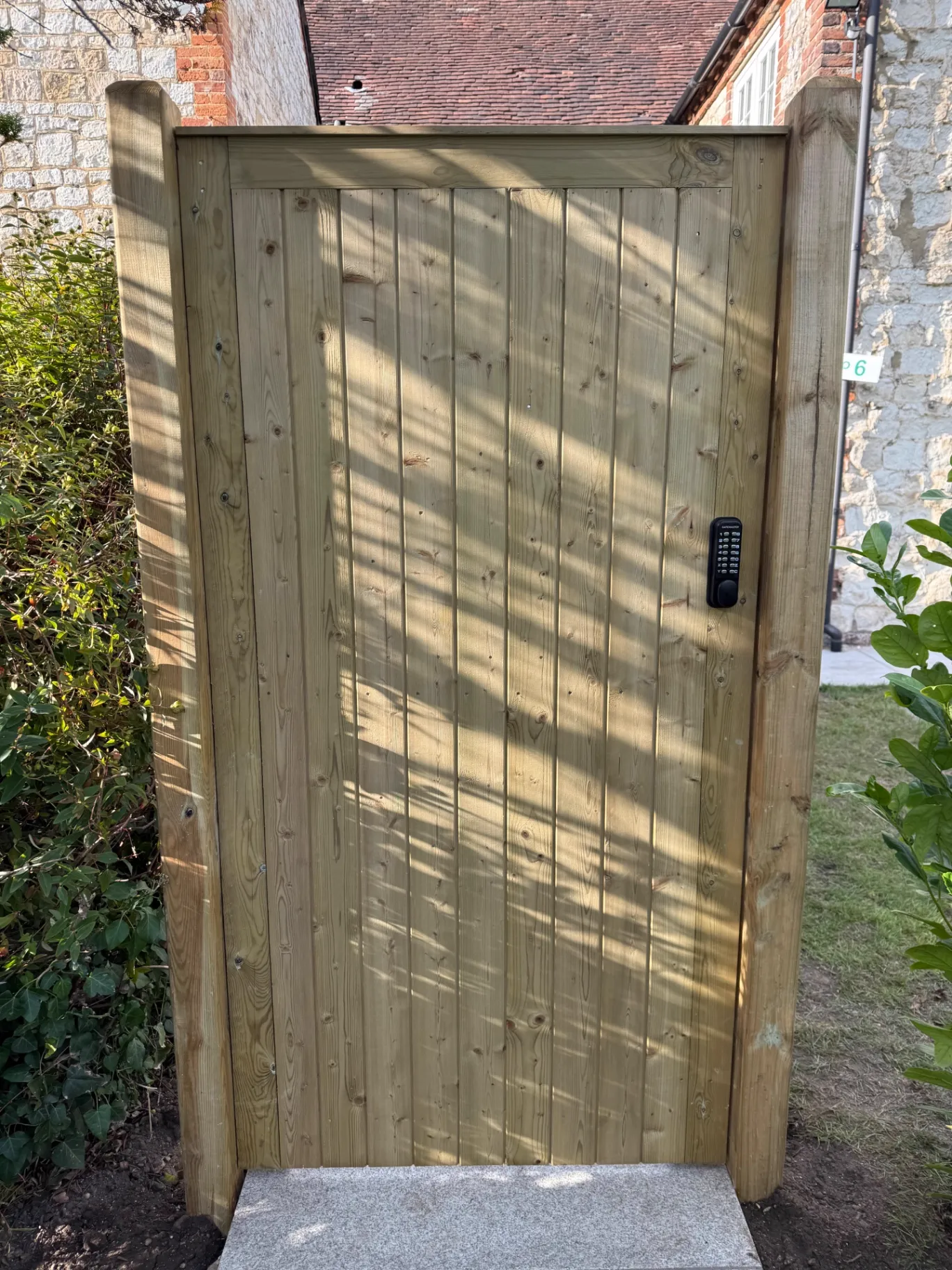 Tall timber side gate with a keypad lock fitted between hardwood posts